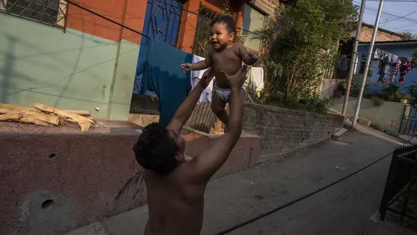A father holds his infant son in San Salvador, El Salvador. 
