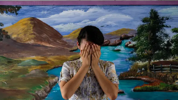 Patricia, 14, covers her face at a school in San Salvador, El Salvador. 