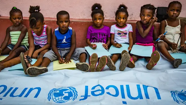 Kids Sitting With a UNICEF Banner