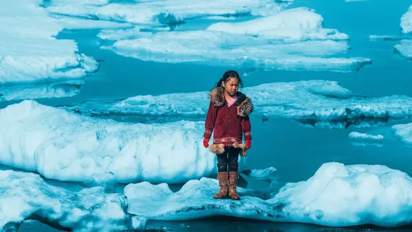Iñupiat girl Amaia, 11, standing on a ice floe on a shore of the Arctic Ocean in Barrow, Alaska in the United States of America. The anomalous melting of the Arctic ice is one of the many effects of global warming.