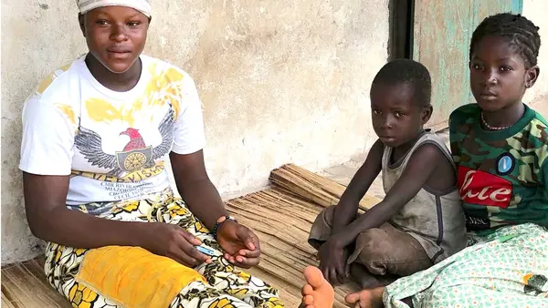 Aïssata Diaby, who lost her first child to tetanus, with her younger siblings in Tambayah, a village in Guinea.