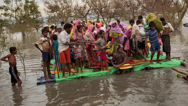 Rohingya refugees crowd onto a makeshift raft to cross the Naf River that separates Myanmar and Bangladesh, in November 2017.