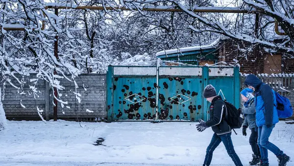 Twelve-year-old Sasha, left, walks to school in the town of Avdivka, Donetsk Oblast, Ukraine, November 2017. Because of shelling and lack of heat, his school is open only three days a week. 