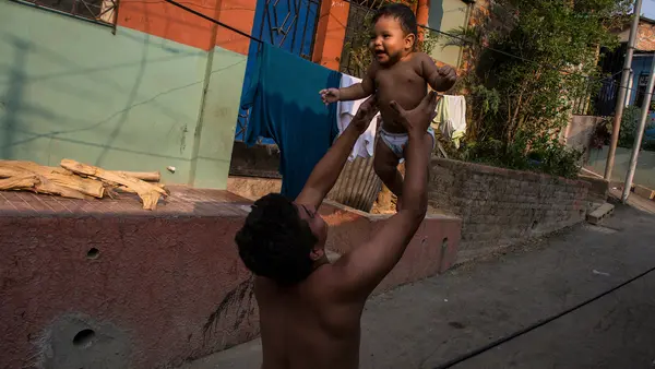 A father holds his infant son in San Salvador, El Salvador. 