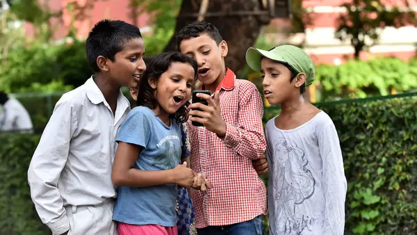 Four Children Looking at Phone