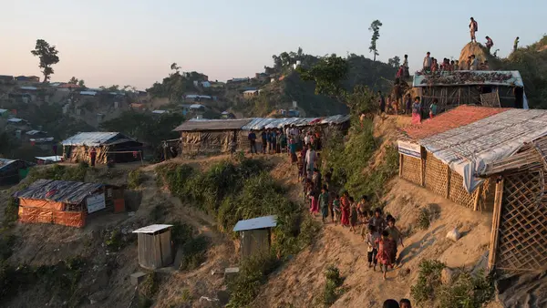 Rohingya refugee children walk along a narrow path hugging a steep slope at the Unchiprang spontaneous site, Cox's Bazar District, Bangladesh, January 2018. 