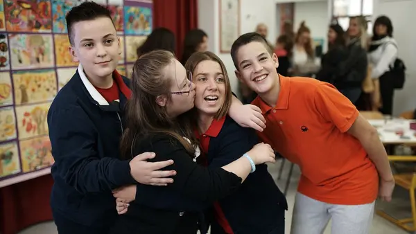 Lucy Meyer, an advocate for children with disabilities, receives a warm welcome from children during a school visit in Kosovo.