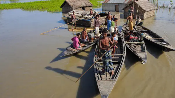 A family take to their boats after severe flooding in 2017 in the northern district of Kurigram, Bangladesh.