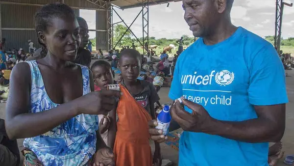 On 21 March 2019 in Malawi, UNICEF WASH Officer Alan Kumwenda shows Anne Joseph, 24, how to use water guard. Anne lost her home in the floods. She saved her children, including 1-week-old Ndaziona, with just minutes to spare. The house collapsed behind th
