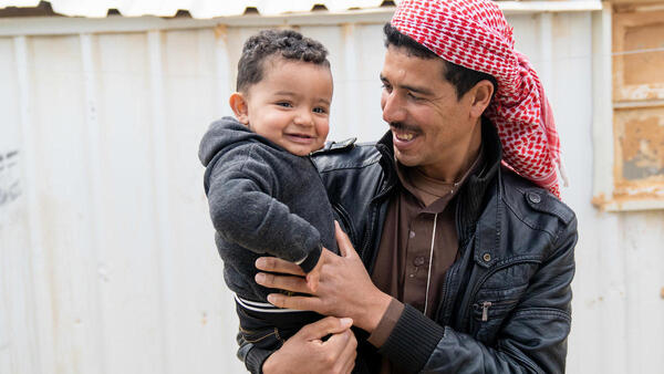 Syrian refugee Shaheen holds his 1-year-old son, Mohammad, in Jordan's Azraq refugee camp. Mohammad was born in the camp's UNICEF-supported pediatric ward.