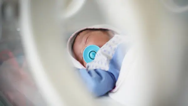 A newborn baby lies in the nursery at Alsadaqah Hospital, supported by UNICEF, in Aden, Yemen. 