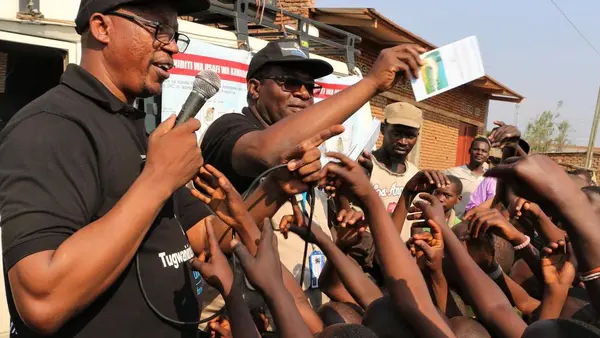 On August 7, 2019, Jean Louison Miango Makunda, UNICEF Burundi's Communication for Development consultant on Ebola preparedness (center) distributes leaflets during an awareness event in Gatumba, Burundi. 