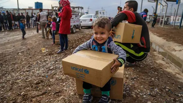 Young Boy Holds UNICEF Box 