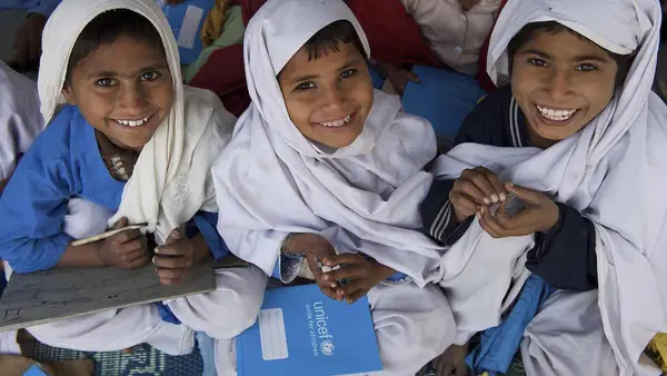 Children smile while attending school in a UNICEF-supported Temporary Learning Centre (TLC) in the village of Basti Bhaya in Rajanpur, amongst one of the worst affected district in Punjab province. 