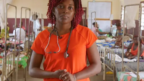 Woman Stands in Front of Room Full of Beds