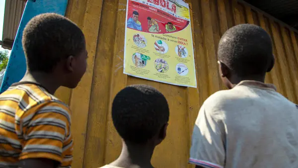 Children read an Ebola-awareness poster in North Kivu, the Democratic Republic of the Congo (DRC).