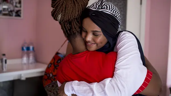 Born a refugee herself, UNICEF Ambassador Halima Aden hugs a young asylum seeker at a UNICEF-supported reception center in Palermo, Italy on August 7, 2019.