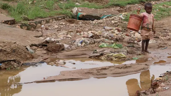 A child plays in a muddy road in the Kinama neighborhood of Bujumbura, Burundi after torrential rains flooded the region. 