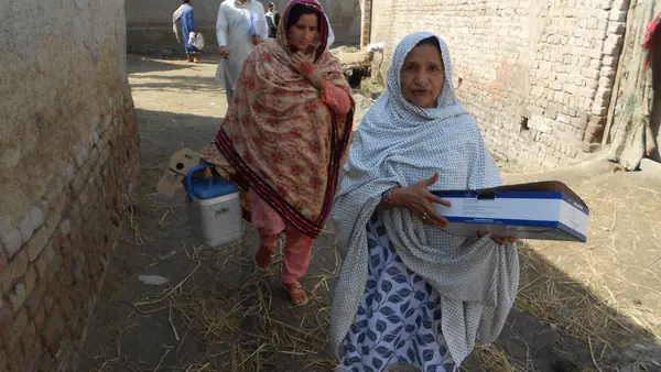 In Pakistan's Kambar District, UNICEF-supported "lady health workers" Jameela, right, and Shamul visit the village of Peer Go Goth to vaccinate women against tetanus. 