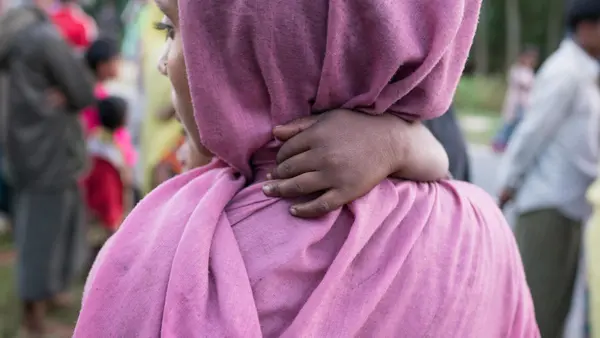 A Rohingya refugee mother and baby on the shores of Bangladesh after crossing by boat from Myanmar to escape genocidal violence.