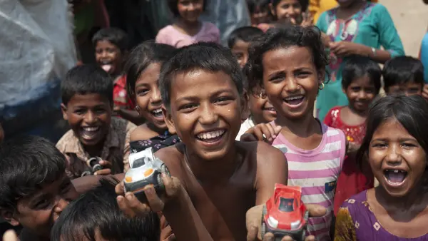 Mohammad Rifat, 12, (shirtless, center) and his friends race toy cars down a sandy stretch of trail in Shamlapur camp, Cox's Bazar District, Bangladesh on April 22 2018