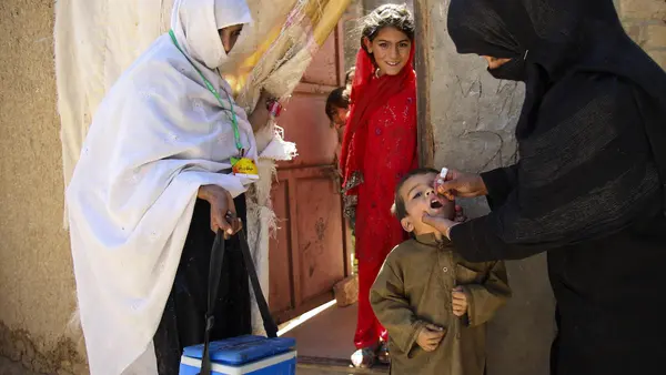 A UNICEF-trained health worker vaccinates a child against polio outside the family's home in Quetta, Balochistan Province, Pakistan. 