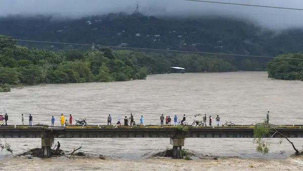 People watch the Humuya river flooding due to heavy rains caused by Eta Hurricane, in Santa Rita, Yoro department, 240 km northern Tegucigalpa, on November 3, 2020.