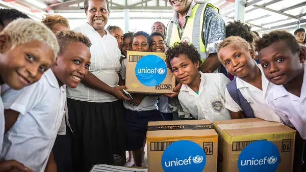 A school teacher, students of White River School in Honiara and a staff member of Red Cross holding a box with soap and other hygiene items provided to the school by UNICEF. This took place during a workshop organised by UNICEF with their partners from th