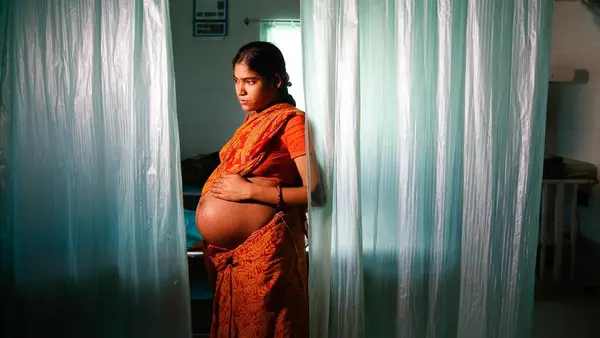 A pregnant woman in India waits to be seen by the hospital physician.