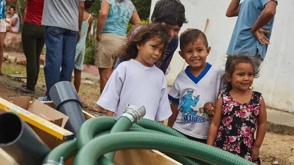 Children watch while UNICEF staff and partners install a water tank which will provide access to safe drinking water to an estimated 24,000 people a month in San Antonio, Tachira state, Venezuela.  