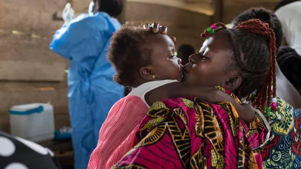 A mother kisses her daughter at a regularly scheduled, UNICEF-supported immunization clinic in the village of Kuka on the outskirts of Beni in North Kivu province, Democratic Republic of the Congo on 21 October 2019. 