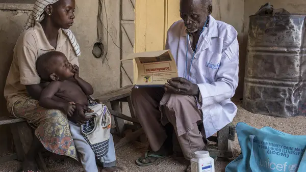 On January 13, 2020, Loveleen Anex, 25, holds her 9-month-old daughter, Ensteen, as UNICEF-supported health worker Benjamin Daniels does a general health check on the child in the village of Jarede, Adamawa state, Nigeria. 