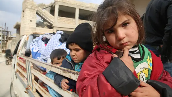 Children ride on the back of a truck heading out of south rural Idlib, northwest Syria, where escalating hostilities have forced some 875,000 Syrians to flee since December 2019.