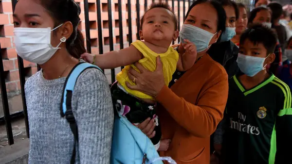 People wearing face masks line up to enter a children’s hospital in Phnom Penh, Cambodia on January 30, 2020 after the nation’s first case of novel coronavirus was reported.
