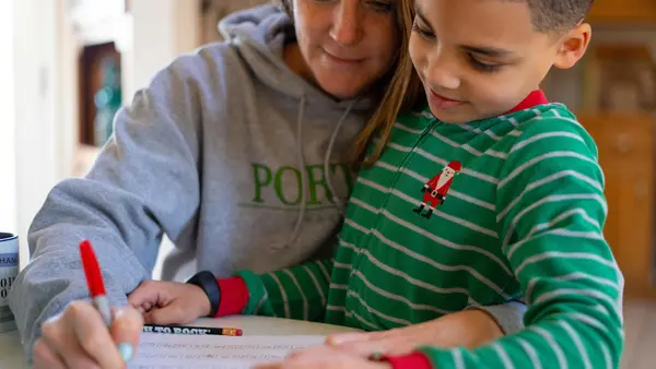 On the morning of March 16, 2020, 8-year-old second grader Luka works on a math assignment at home in Connecticut, with help from his mother, Sophia. 