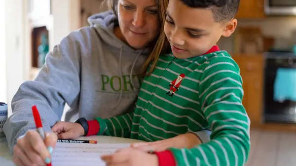 8-year-old second grader Luka works on a mathematics assignment at home in Connecticut, United States of America, with help from his mother, Sophia. Local schools were closed indefinitely effective the Friday before, 13 March, as part of precautions to co