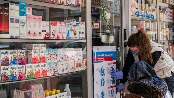 On April 1, 2020, UNICEF volunteers hang posters providing important instructions on how to protect against COVID-19 in Qamishly, a city of some 250,000 in northeast Syrian Arab Republic. 
