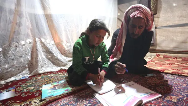 On 9 April 2020, 9-year-old Maria follows a pre-recorded lesson on her father’s smartphone in a tent at the Kili IDP camp in rural Idlib.