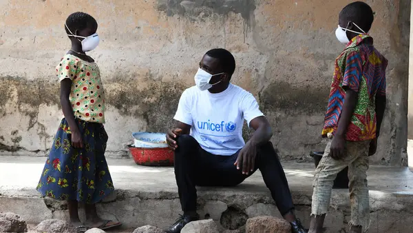 In the village of Morovine, in the North of Côte d'Ivoire, a UNICEF Staff member counsels children on the importance of wearing masks or face coverings to protect themselves against the coronavirus.