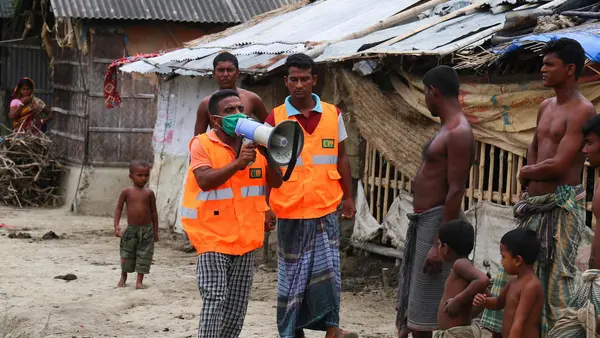 A UNICEF-supported Cyclone Preparedness Program (CPP) volunteer uses a megaphone to urge residents to evacuate to shelters ahead of the expected landfall of cyclone Amphan in Khulna, Bangladesh on May 19, 2020.