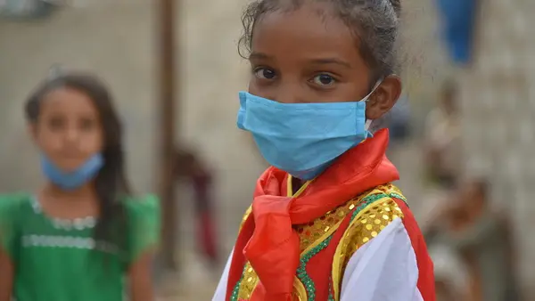 Seven-year-old Jabra wears a mask to prevent transmission of the novel coronavirus in Yemen in 2020.
