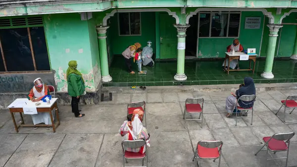 A child is weighed at a health post in Sidorejo village, Central Java province, Indonesia.