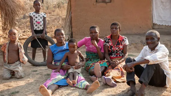 In Malawi's Ntcheu District, Wilson Kamwana, 84, far right, and his extended family use the $7 a month they receive from a UNICEF-supported unconditional cash transfer program to pay for basic necessities like soap, salt, sugar and school supplies. 