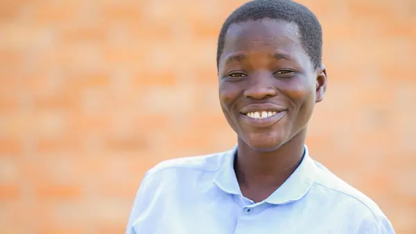 Nelia, 18, is on track to receive her secondary school diploma at Mpamba Community Day Secondary School in Nkhatabay District, Malawi, with help from a scholarship provided by the Kids in Need of Desks (K.I.N.D.) Fund.