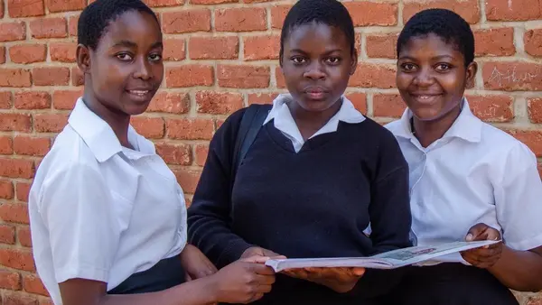 Sixteen-year-old Atupele, center, and classmates attend Salima Secondary School in central Malawi. A Kids In Need of Desks (K.I.N.D.) scholarship covers her school fees, uniform and school supplies. 