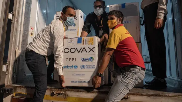 People Carrying COVAX Boxes