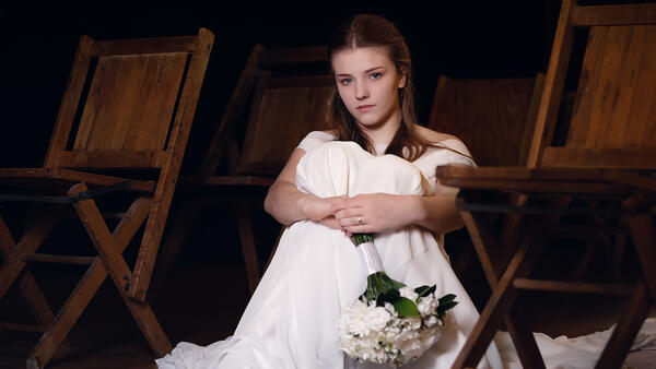 Young Girl Sitting on Floor in White Dress
