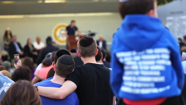 People listen to Joseph Borgen, a recent victim of a hate crime, speak during a rally denouncing antisemitic violence on May 27, 2021 in Cedarhurst, New York. 