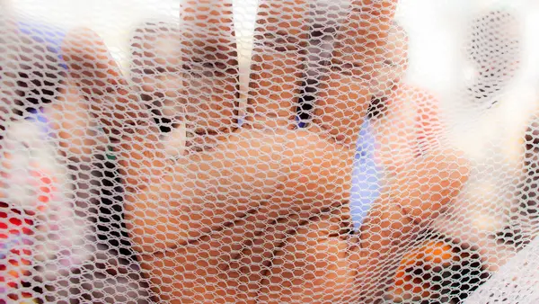 Hand Behind a Net