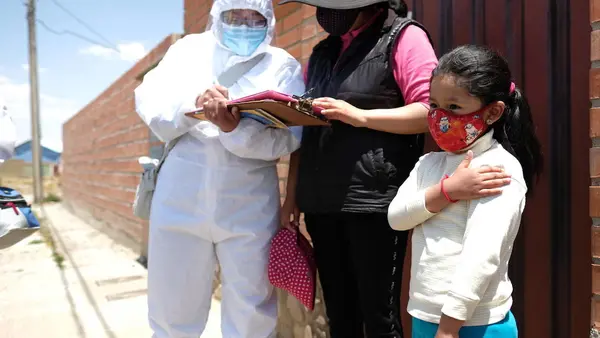 On October 13, 2020 in El Alto, Bolivia, 6-year-old Noelia gently touches her arm where she received a flu shot from a member of aUNICEF-supported vaccination team that goes door-to-door. 